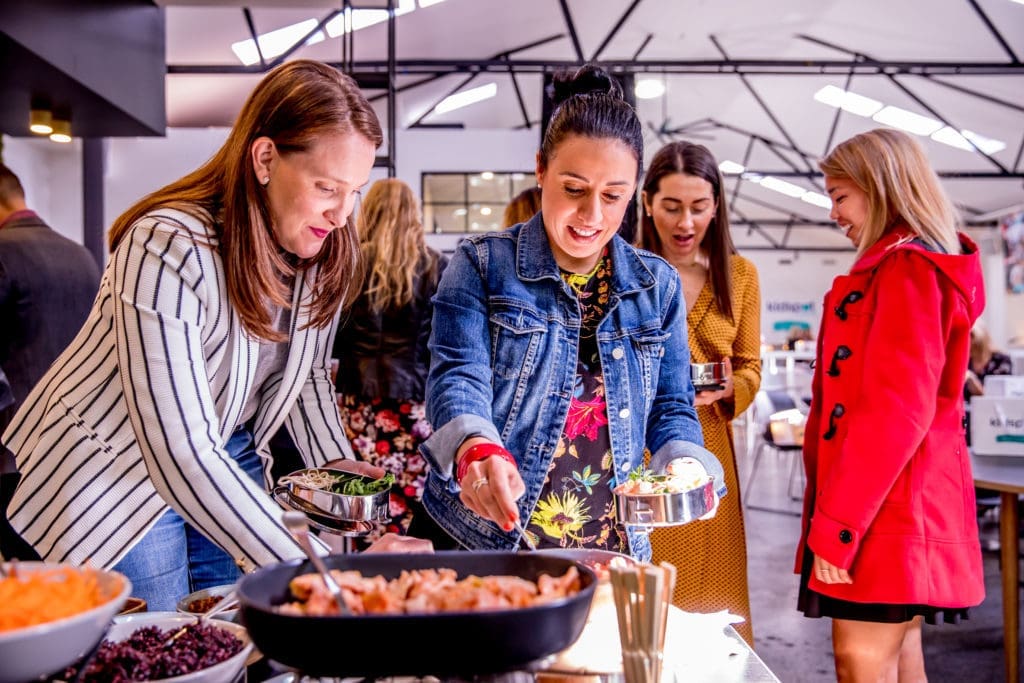 A group of women enjoying dishes and conversation at a food event at Canvas House