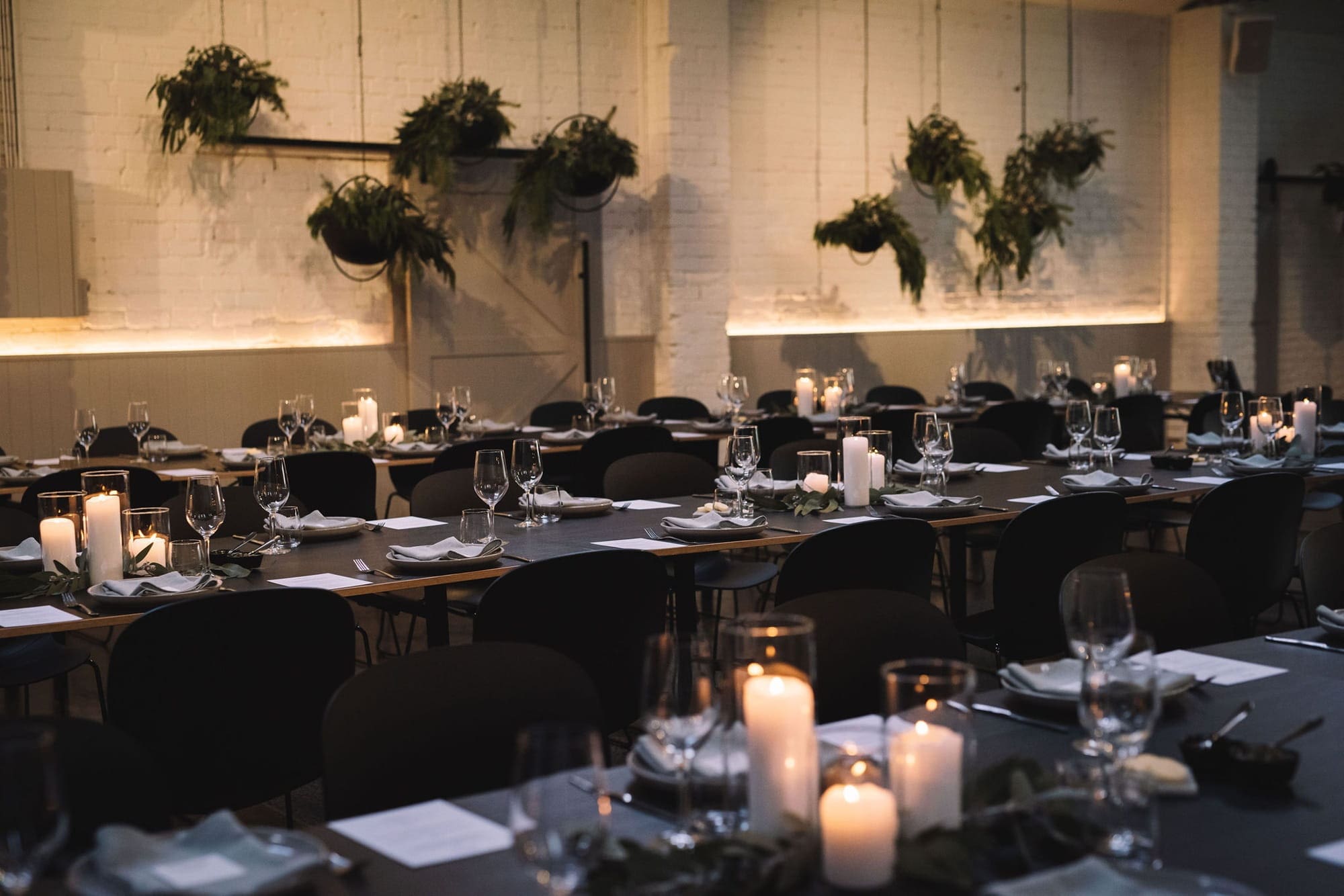 A beautifully arranged long table featuring candles and greenery, perfect for seasonal wedding ambiance.
