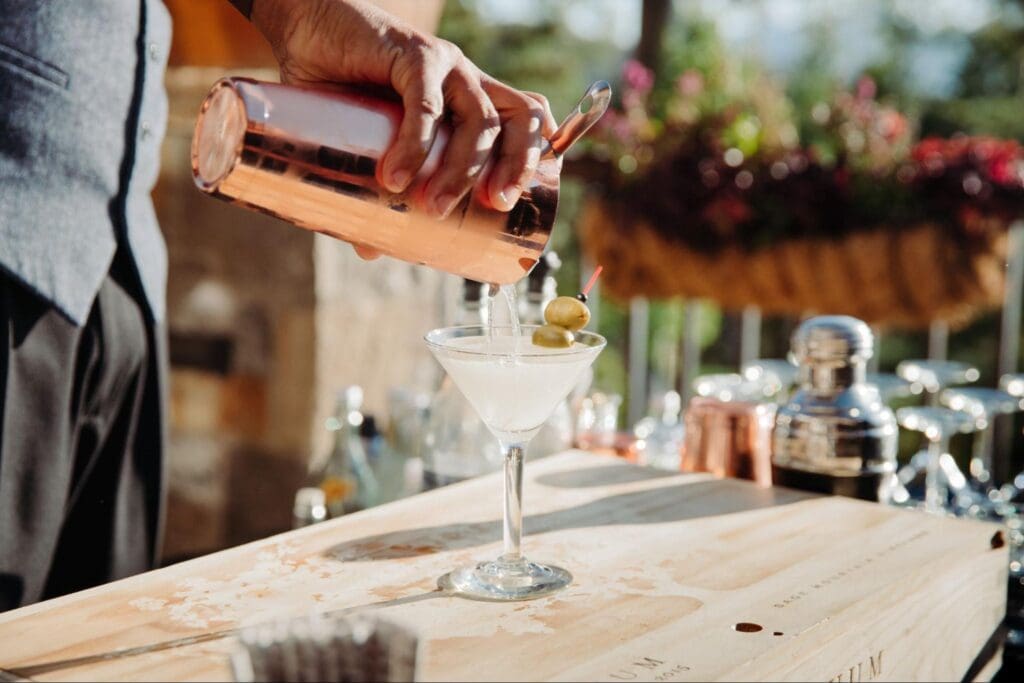 Bartender pouring a martini into a glass