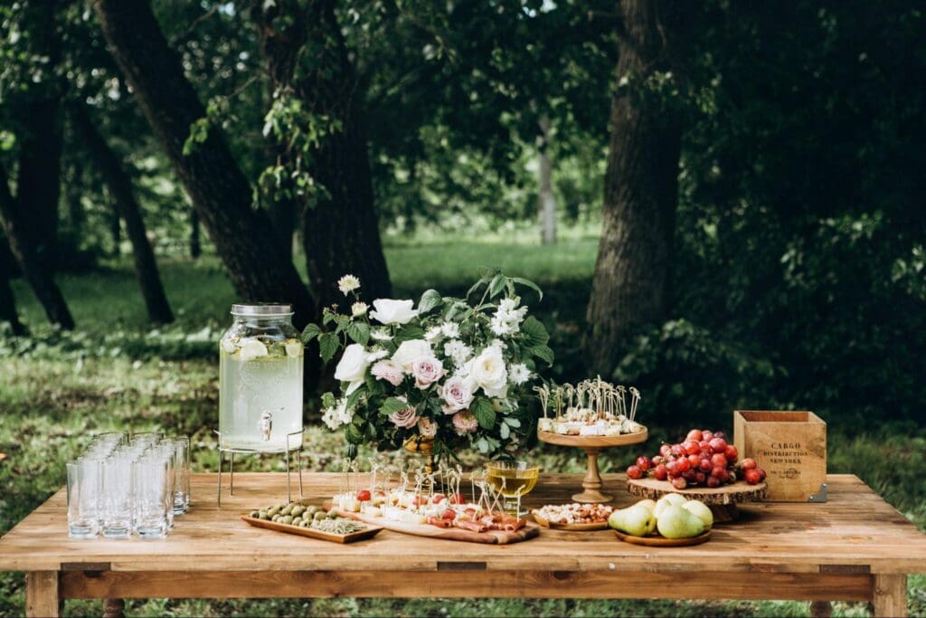 Outdoor catering setup with food and floral arrangement