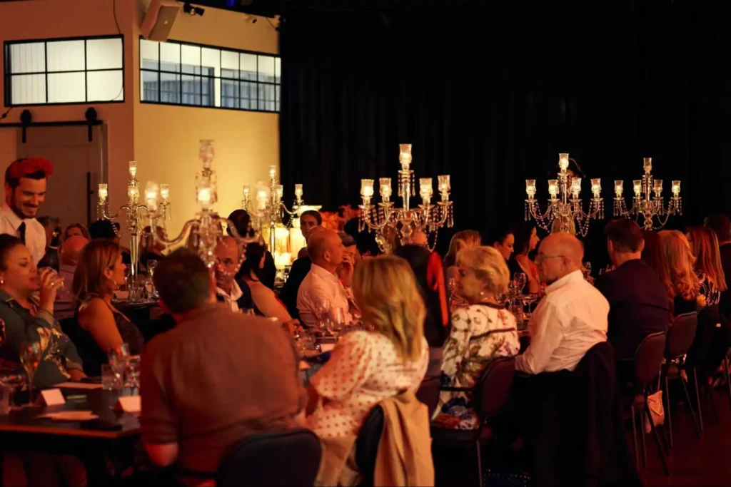 Elegant dinner setup with chandeliers at a corporate event