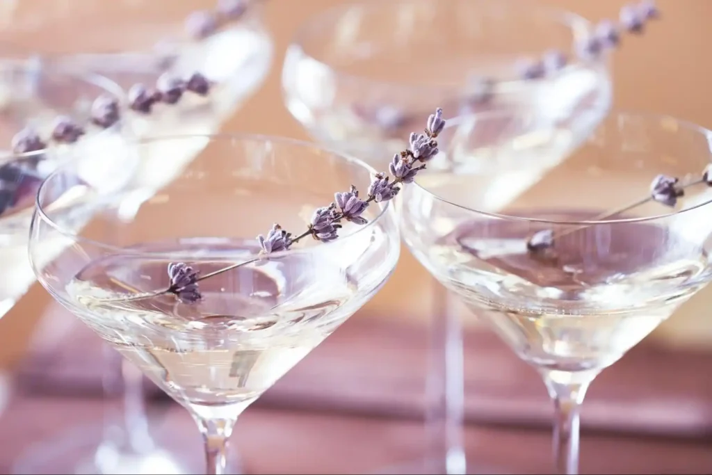 Elegant coupe glasses with clear cocktails, garnished with sprigs of lavender, creating a sophisticated and refreshing presentation.