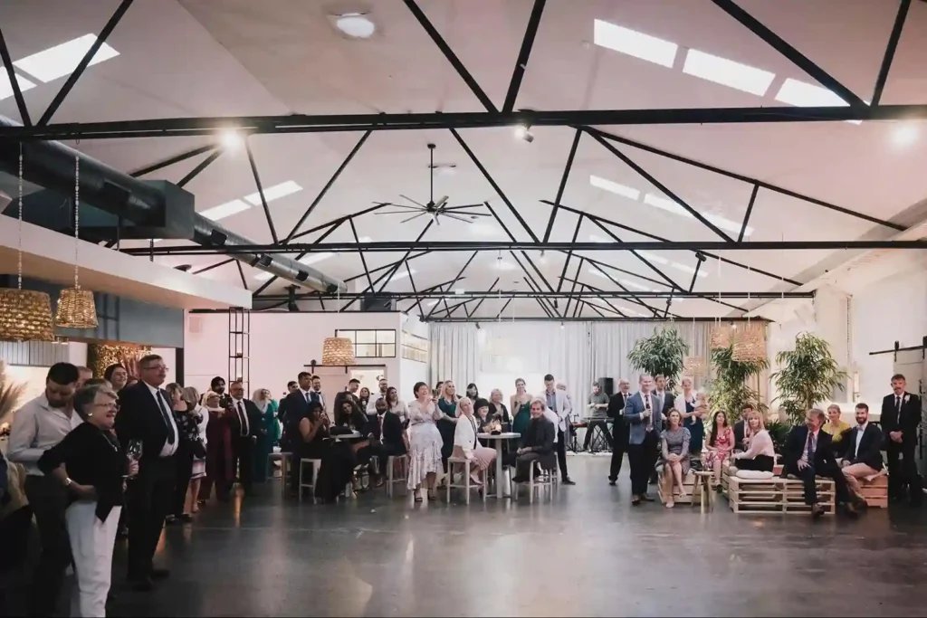 Guests mingling and seated during a formal event in a canvas house venue.