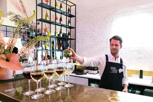 Bartender pouring wine at an elegant event bar.