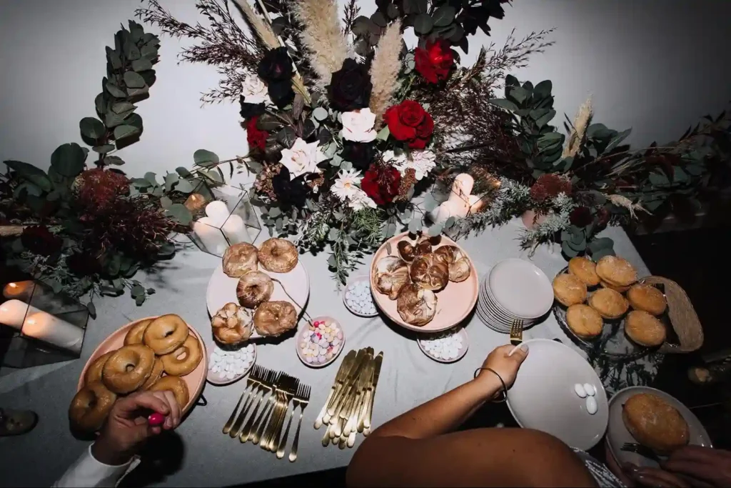 Decorative table with pastries and floral centrepieces at a buffet.