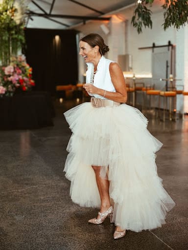 Nash wears a white dress with a tulle skirt, showcasing a stylish and elegant look. 